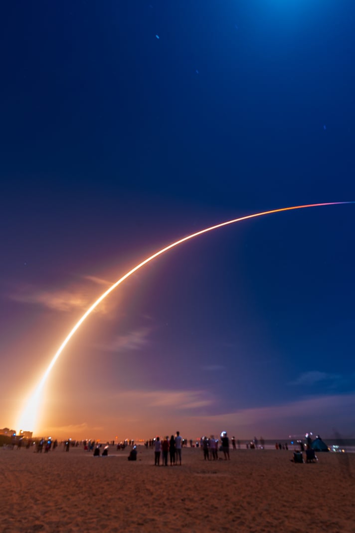 People on the Beach Looking at a Rocket Launch 